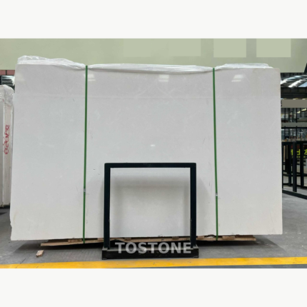White Sand Beige Marble slab bundle with a pale cream surface, green straps and a black support frame.