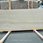 Wide White Travertine Slab with soft horizontal gray bands on timber supports