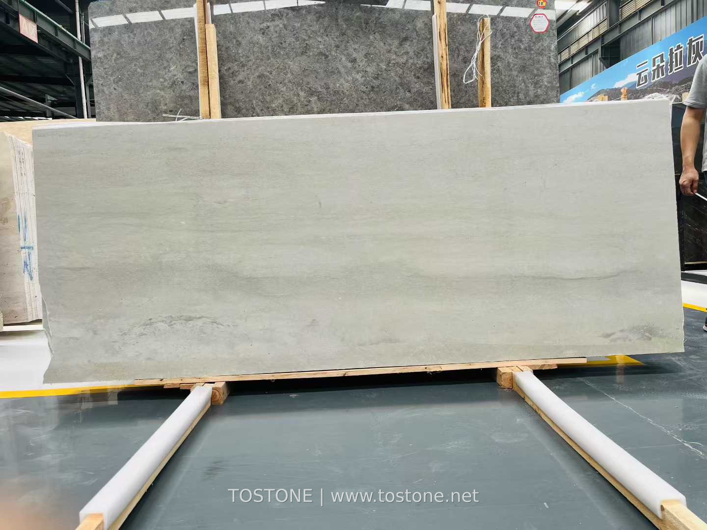 white-travertine-slab-01-tostone-watermark Wide White Travertine Slab with soft horizontal gray bands on timber supports
