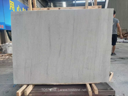 White Travertine Slab with fine vertical markings displayed in a workshop