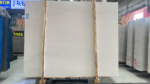 Tall White Travertine slabs held by timber braces in a warehouse