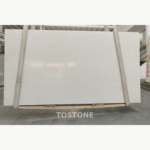 Ya Shi White Jade Marble slab held by lifting straps with faint grey mottling across the white face